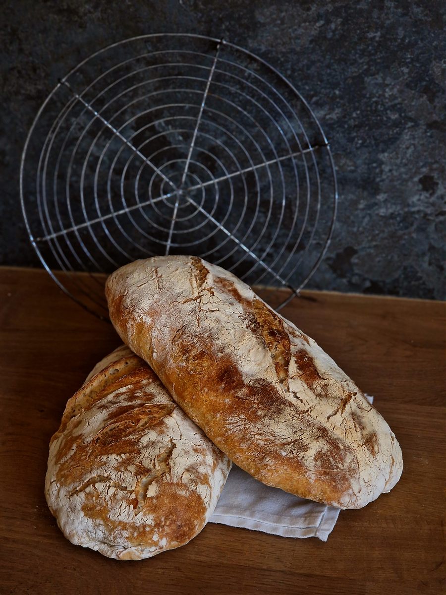 Ciabatta with an open, airy crumb, cooling on a wire rack